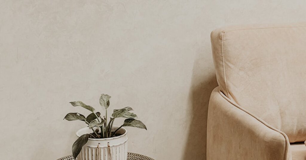 Elegant minimalist living room with beige sofa and potted plant in Kozhikode, India.