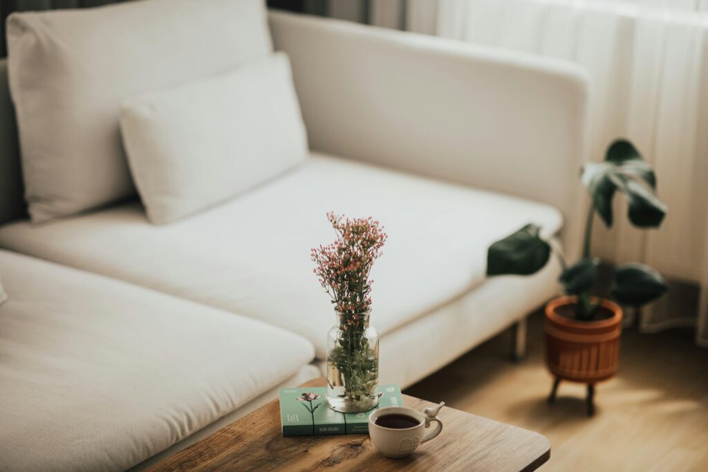 Inviting living room scene with a coffee cup and vase of flowers on a wooden table.